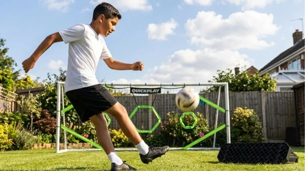 Boy practicing soccer against a wall rebounder