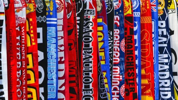 Collection of soccer scarves from clubs and national teams displayed on a wall